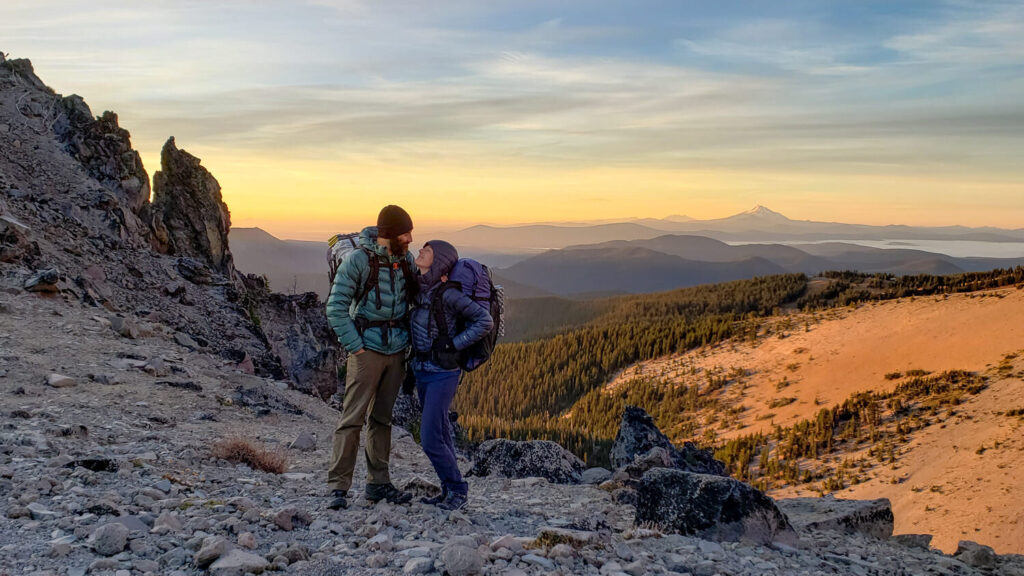 a man and woman kissing on a rocky mountain on Adventure Traveling