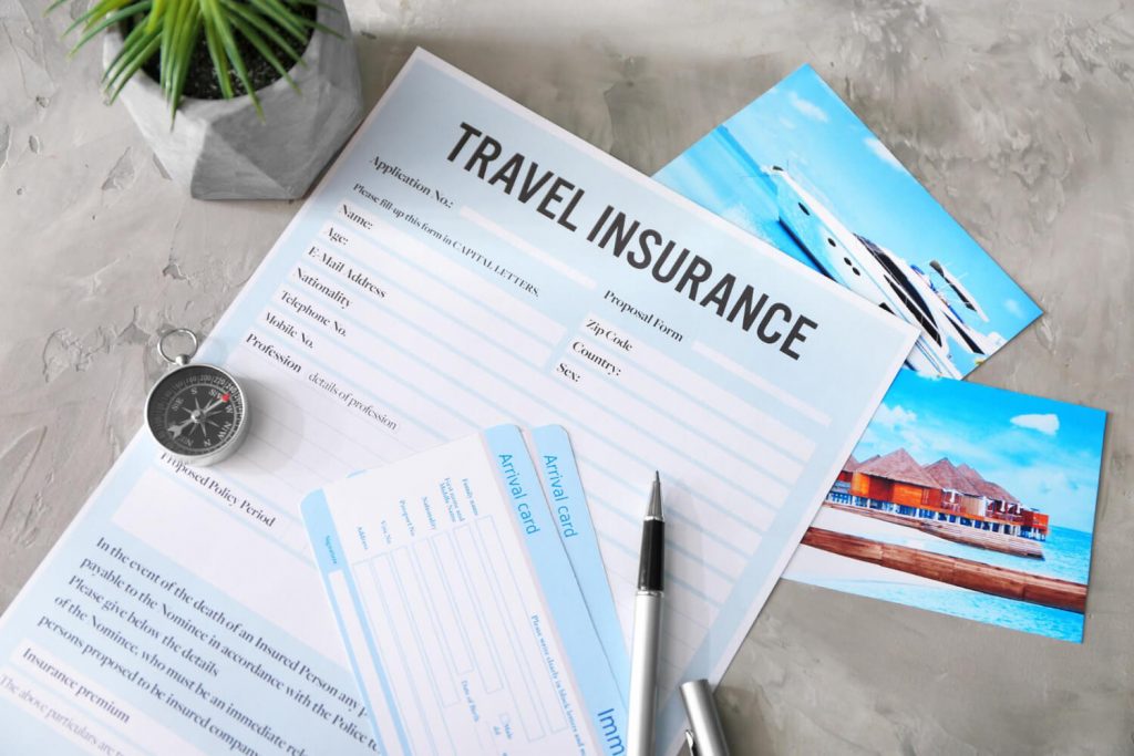 a Travel Insurance form with a pen and a compass