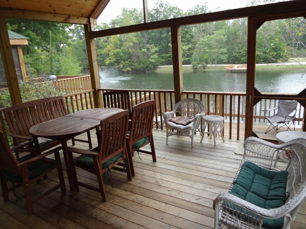 a deck with a table and chairs and a pond on Summer Destinations